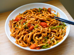 A colorful bowl of veggie-based spinach noodles served with vegetables, highlighting healthy maida-free ingredients